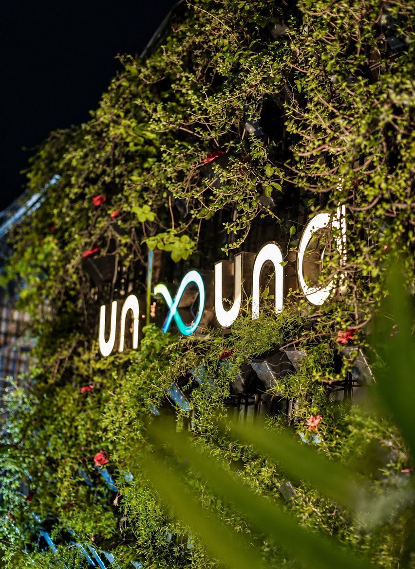 The lit UnBound sign in the green wall at night